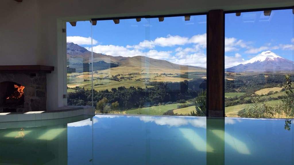 Piscina interior temperada con el Cotopaxi visible a través de las ventanas