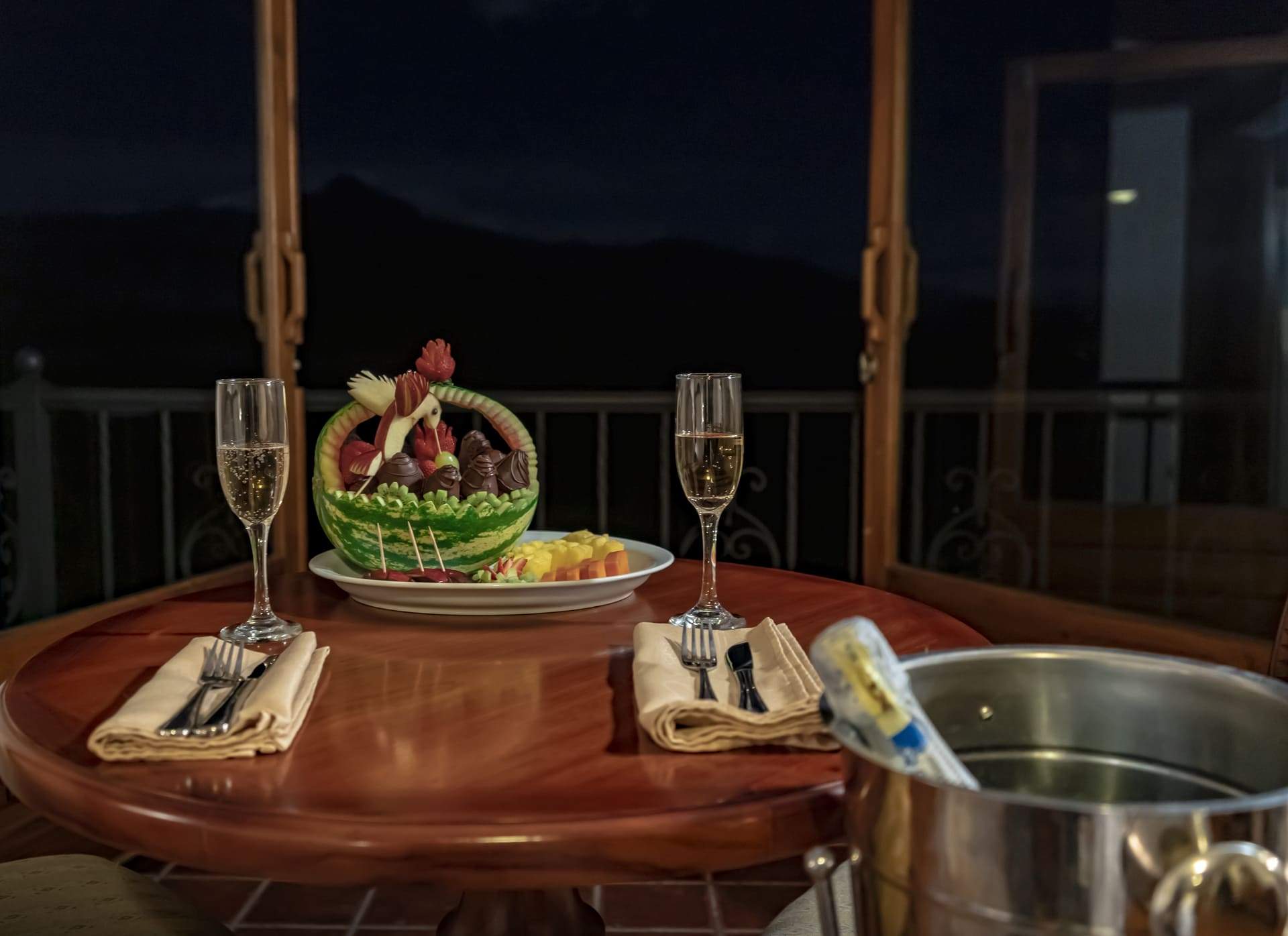 Mesa preparada para la cena junto a las ventanas por la noche